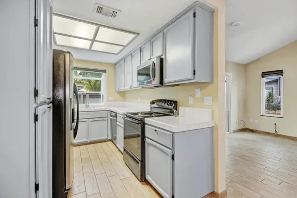 a kitchen with stainless steel appliances granite countertop a stove a sink and a refrigerator