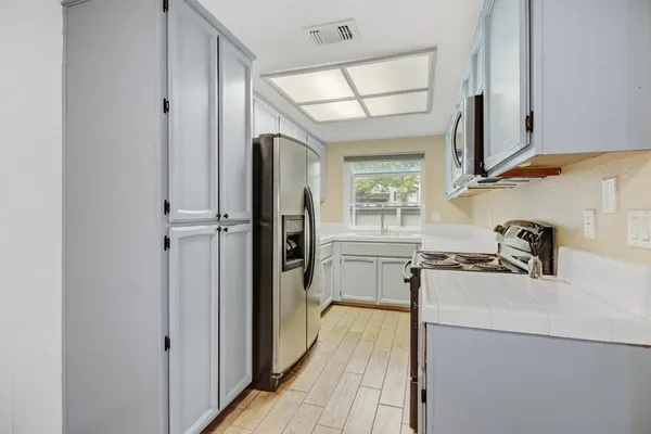 a kitchen with stainless steel appliances granite countertop a sink and a refrigerator