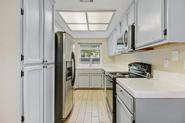 a kitchen with a stove a refrigerator and a sink