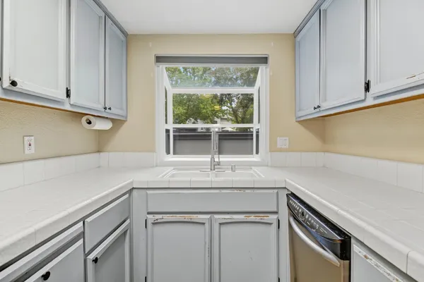 a kitchen with granite countertop white cabinets and a sink