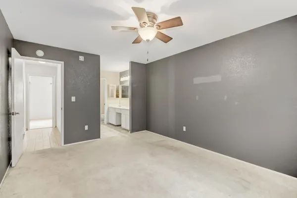 a view of an empty room with a ceiling fan
