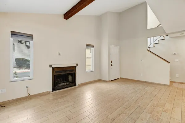 a view of an empty room with a fireplace and a window