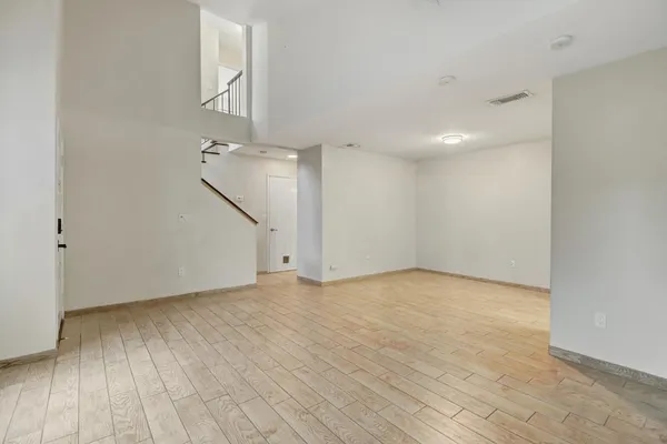 a view of an empty room with wooden floor