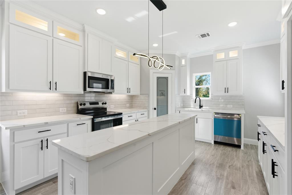420 Ball Street Tom Bean, TX 75491 - Photo 3 of 34 a kitchen with a sink a counter top space stainless steel appliances and cabinets