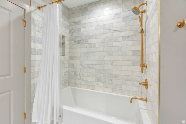 250 South Main Street, Unit 10 Alpine, UT 84004 - Photo 25 of 29 Bathtub with subway-style tile surround, featuring brass fixtures and a built-in shower niche