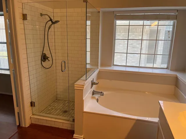 a bathroom with a bath tub with a shower