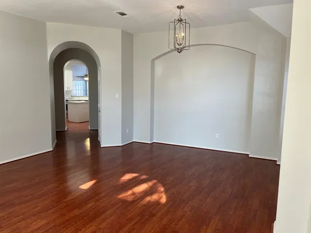 a view of empty room with wooden floor and window