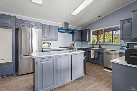 a kitchen with a refrigerator sink and cabinets