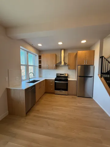 a large kitchen with a large counter top space stainless steel appliances and a window