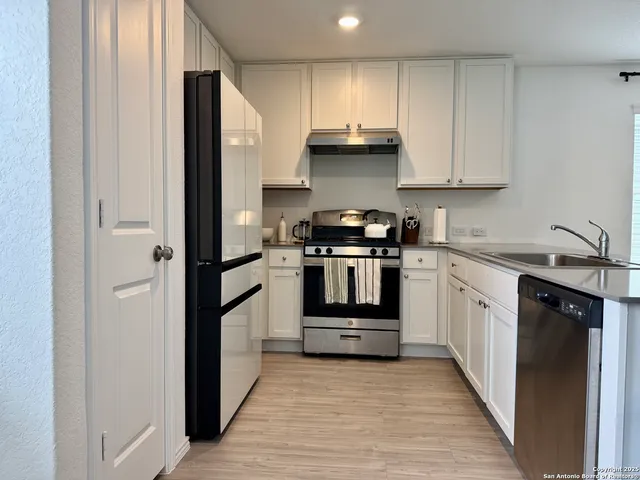 a kitchen with a white stove top oven and refrigerator