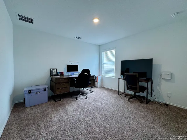 a view of a livingroom with workspace and a window