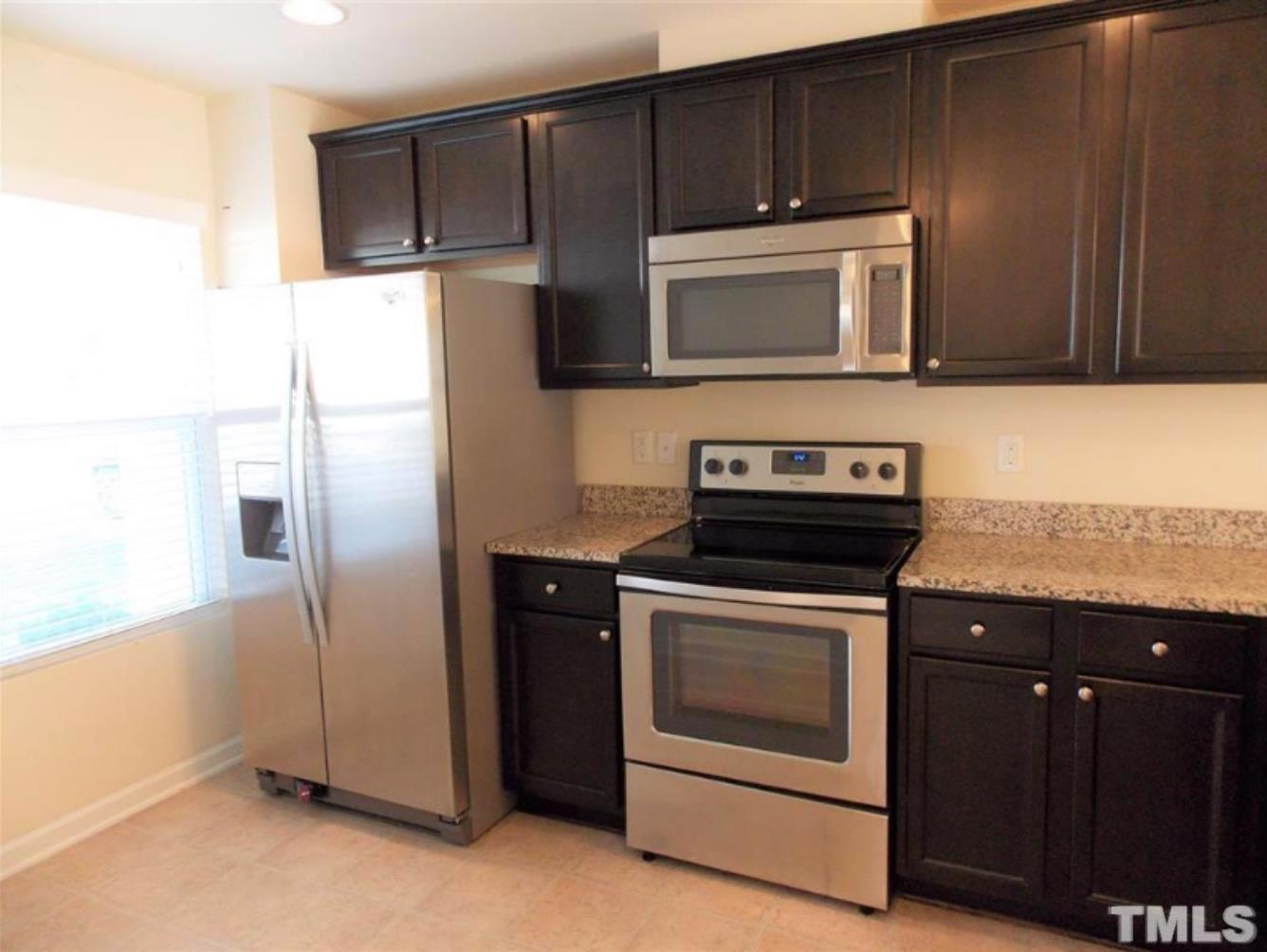 3910 Swinton Street Raleigh, NC 27616 - Photo 4 of 6 a kitchen with granite countertop wooden cabinets and stainless steel appliances