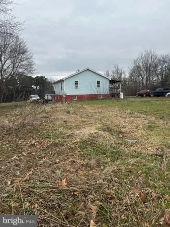 a front view of house with yard and trees in the background