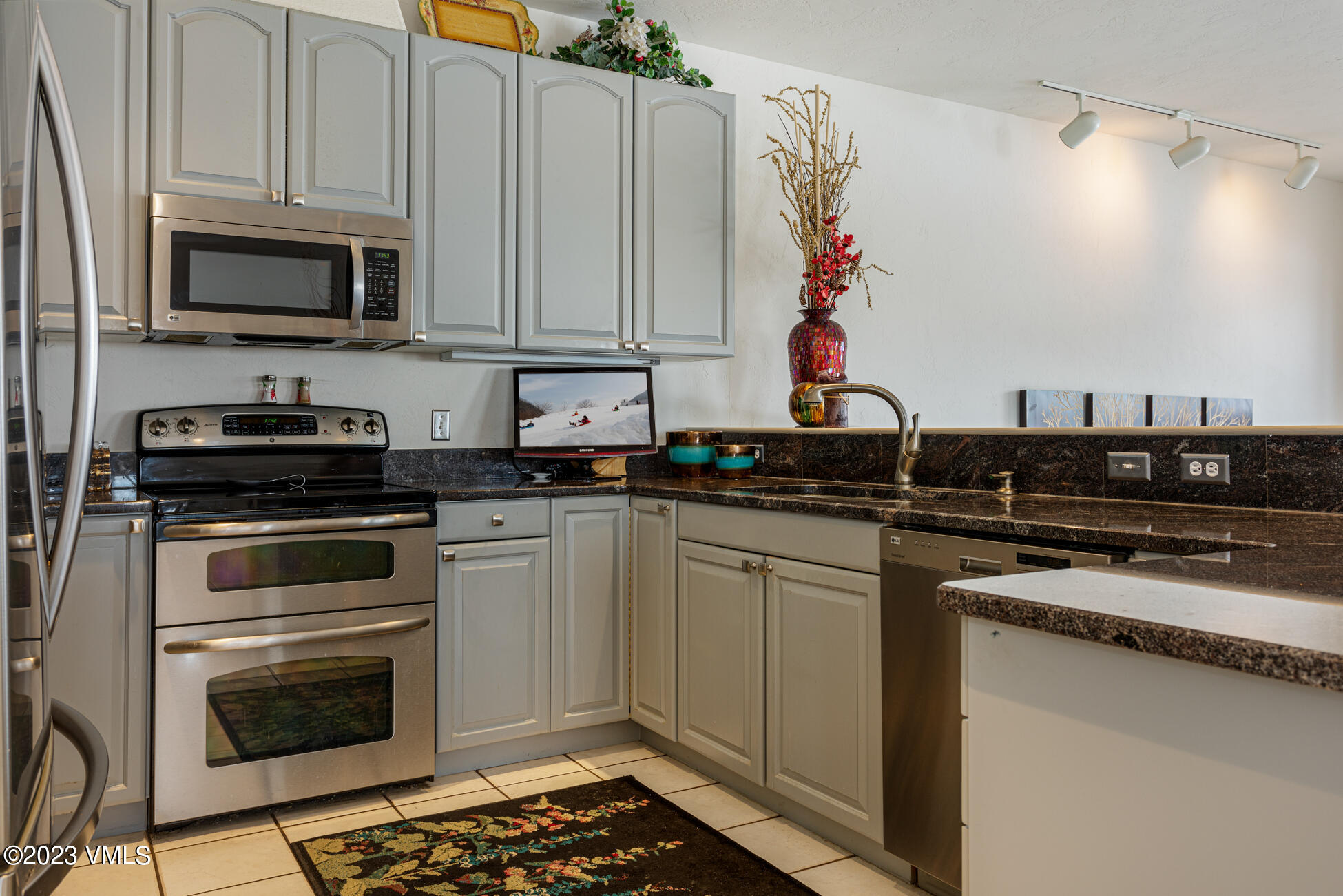 751 Singletree Road, Unit 1 Edwards, CO 81632 - Photo 6 of 16 a kitchen with stainless steel appliances granite countertop a stove a microwave and cabinets