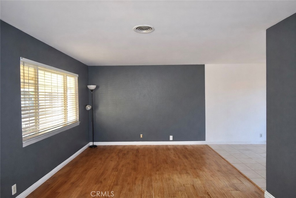 7251 Middlesex Drive Stanton, CA 90680 - Photo 3 of 11 an empty room with wooden floor and windows