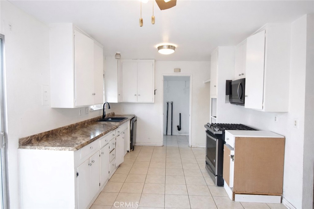 7251 Middlesex Drive Stanton, CA 90680 - Photo 4 of 11 a kitchen with granite countertop a sink a counter top space and stainless steel appliances