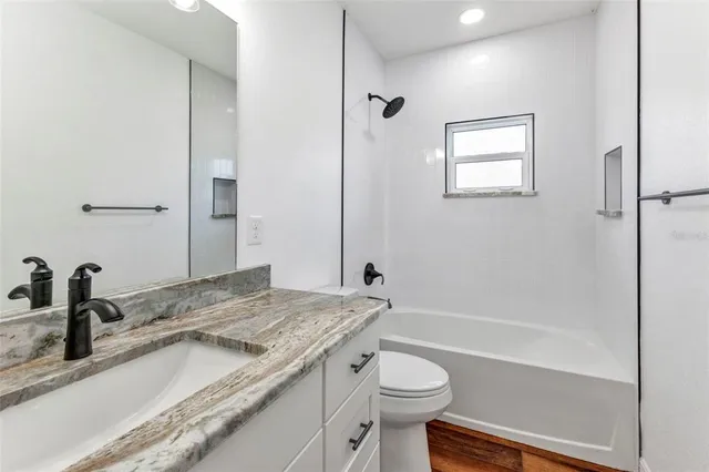 a white toilet sitting next to a bath tub