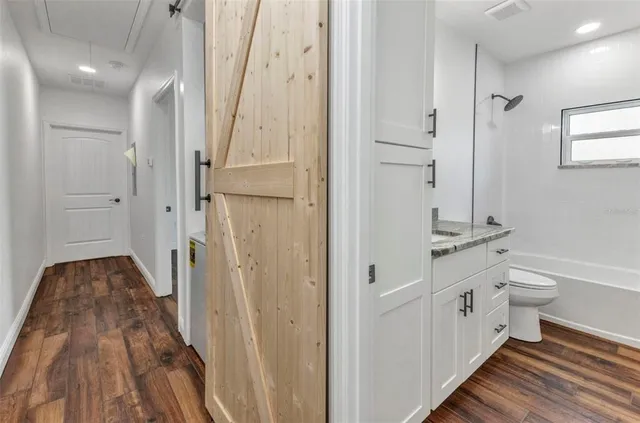 a bathroom with a granite countertop sink a toilet and a mirror