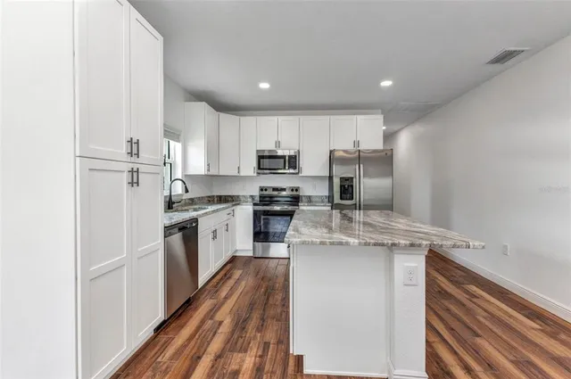 a view of a hallway with wooden floor and closet area