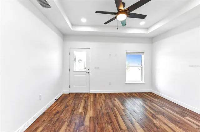 a view of a room with wooden floor and a hallway