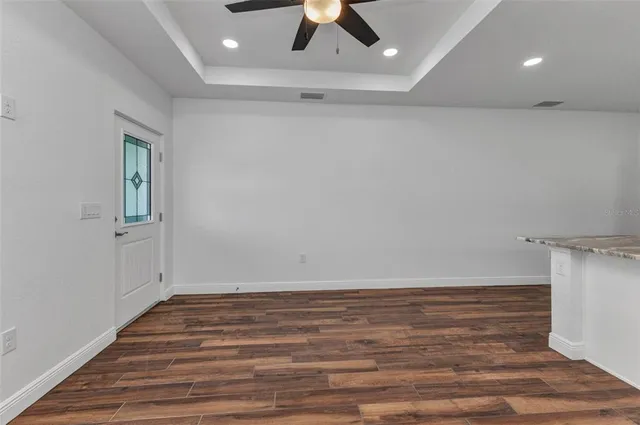 an empty room with a window and a ceiling fan