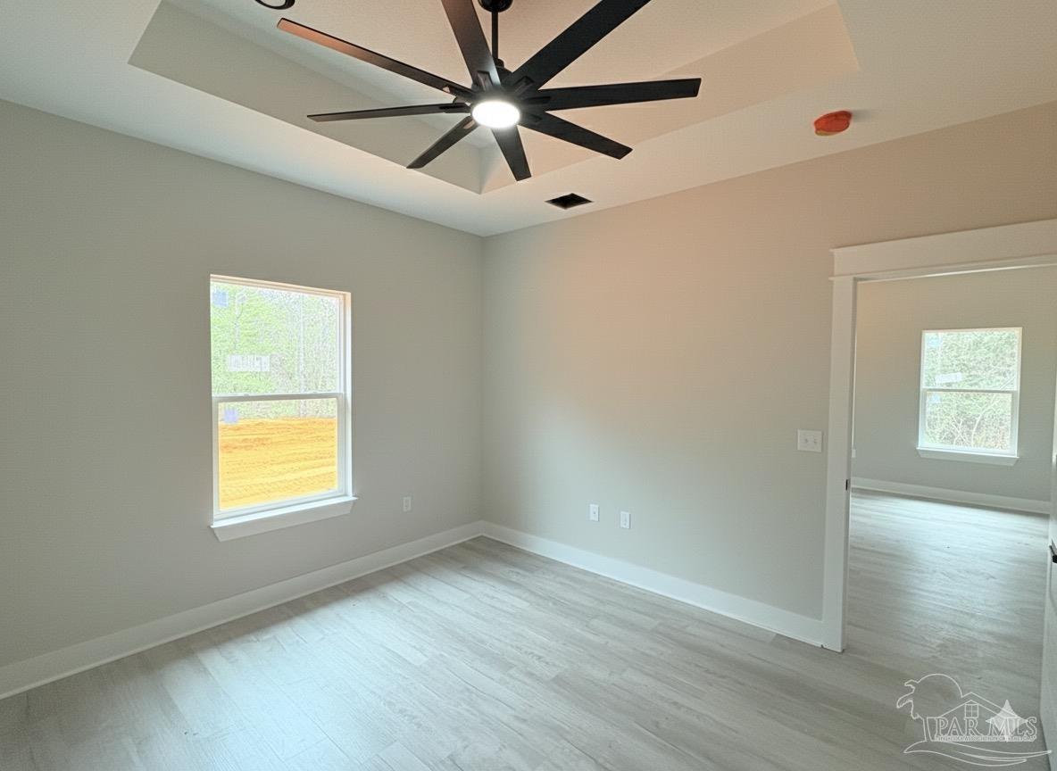 2936 North 14th Avenue Milton, FL 32583 - Photo 11 of 23 an empty room with wooden floor ceiling fan and windows