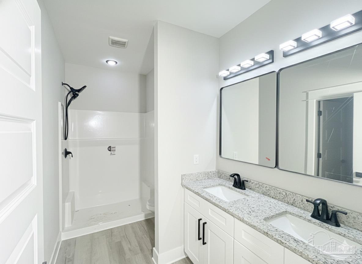 2936 North 14th Avenue Milton, FL 32583 - Photo 12 of 23 a bathroom with double vanity and a mirror