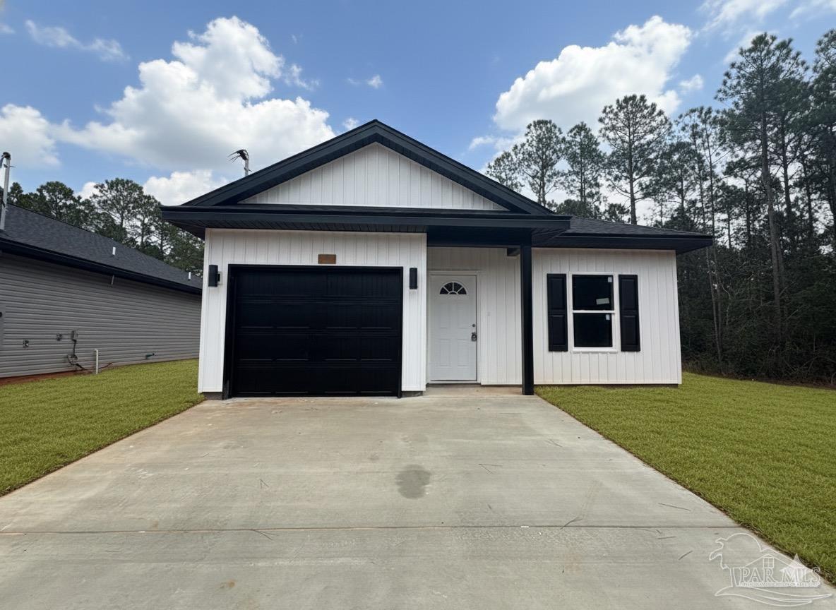 2936 North 14th Avenue Milton, FL 32583 - Photo 2 of 23 a front view of a house with a yard and garage