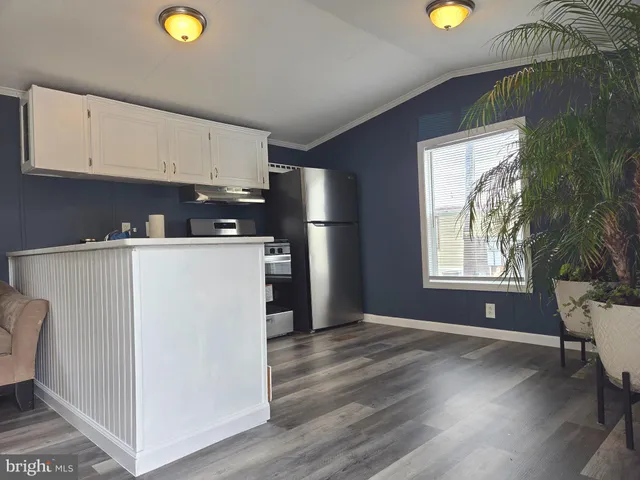 a view of a kitchen with a fridge wooden floor and window