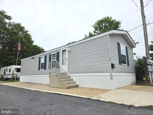 a white house that has tree in front of it