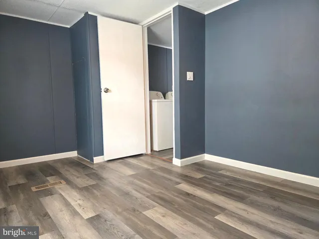 an empty room with wooden floor and closet
