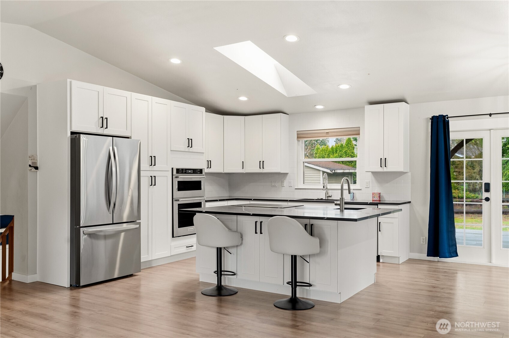 2401 185th Place Southeast Bothell, WA 98012 - Photo 15 of 36 a kitchen with stainless steel appliances granite countertop a refrigerator a sink dishwasher a stove and white cabinets with wooden floor