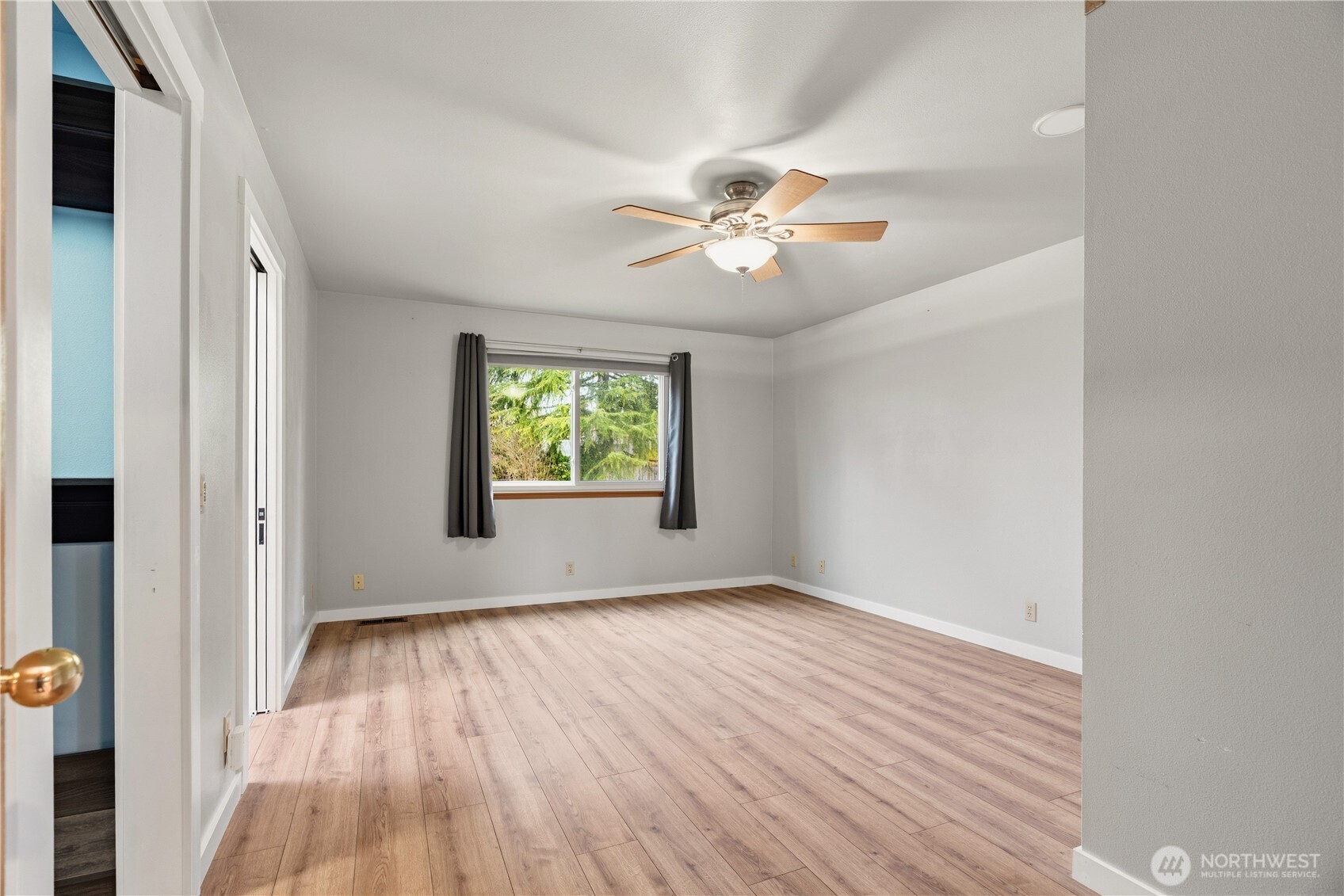 2401 185th Place Southeast Bothell, WA 98012 - Photo 30 of 36 an empty room with wooden floor chandelier fan and windows