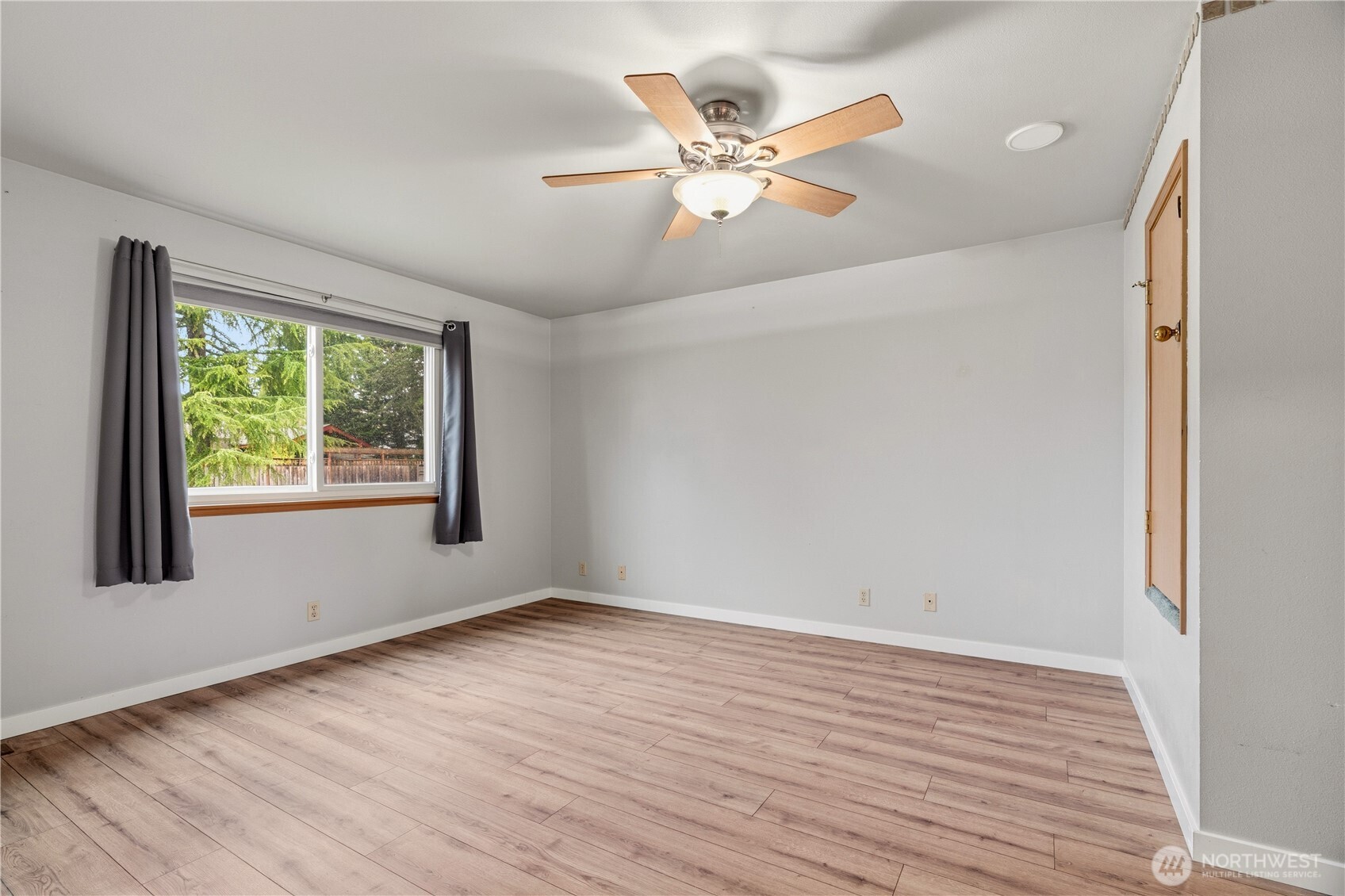 2401 185th Place Southeast Bothell, WA 98012 - Photo 31 of 36 a view of an empty room with wooden floor and a window