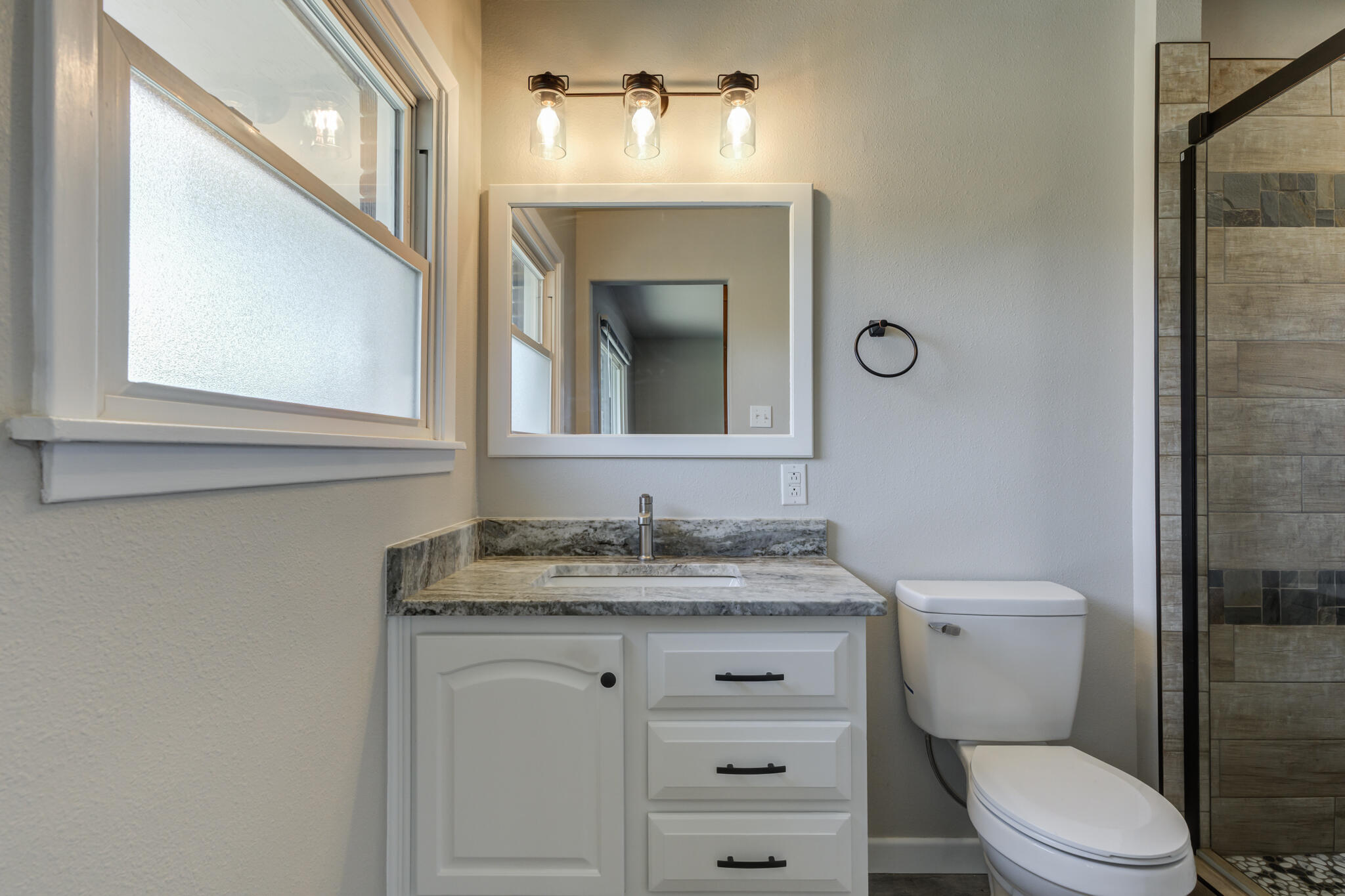 4921 10th Street Lubbock, TX 79416 - Photo 17 of 29 a bathroom with a toilet sink and mirror