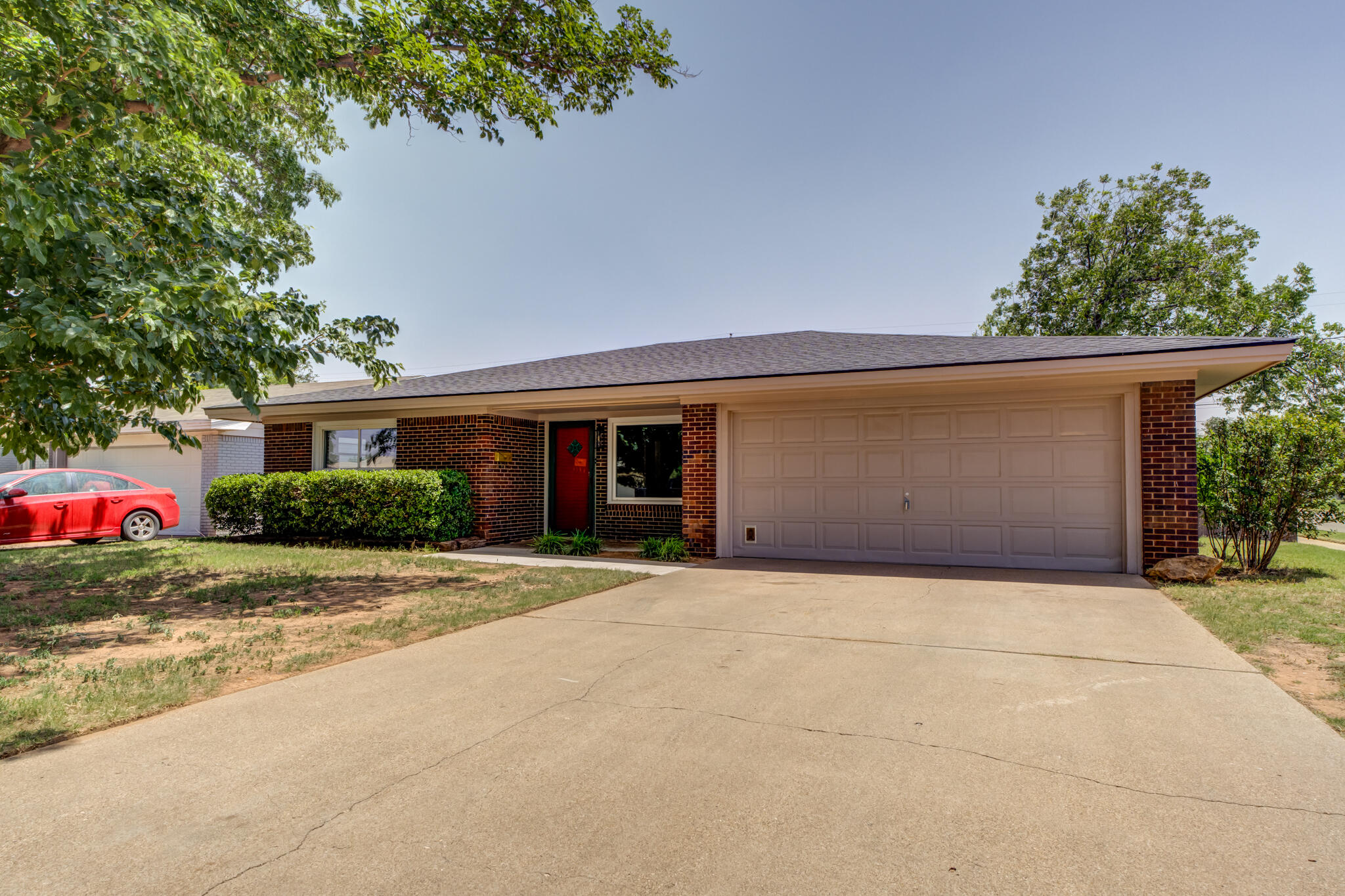 4921 10th Street Lubbock, TX 79416 - Photo 2 of 29 a front view of a house with a yard and a garage