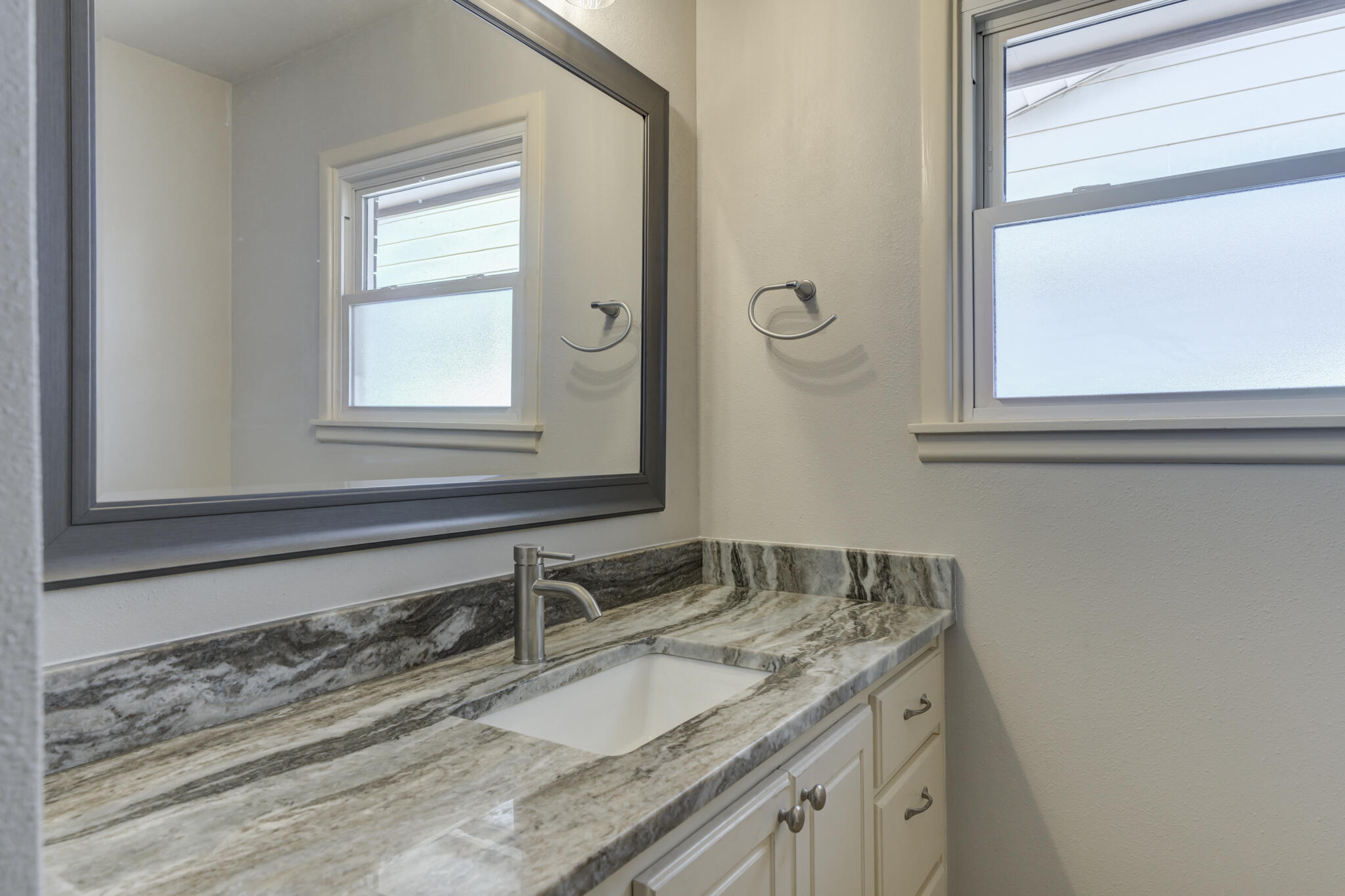 4921 10th Street Lubbock, TX 79416 - Photo 23 of 29 a bathroom with a granite countertop sink and a mirror