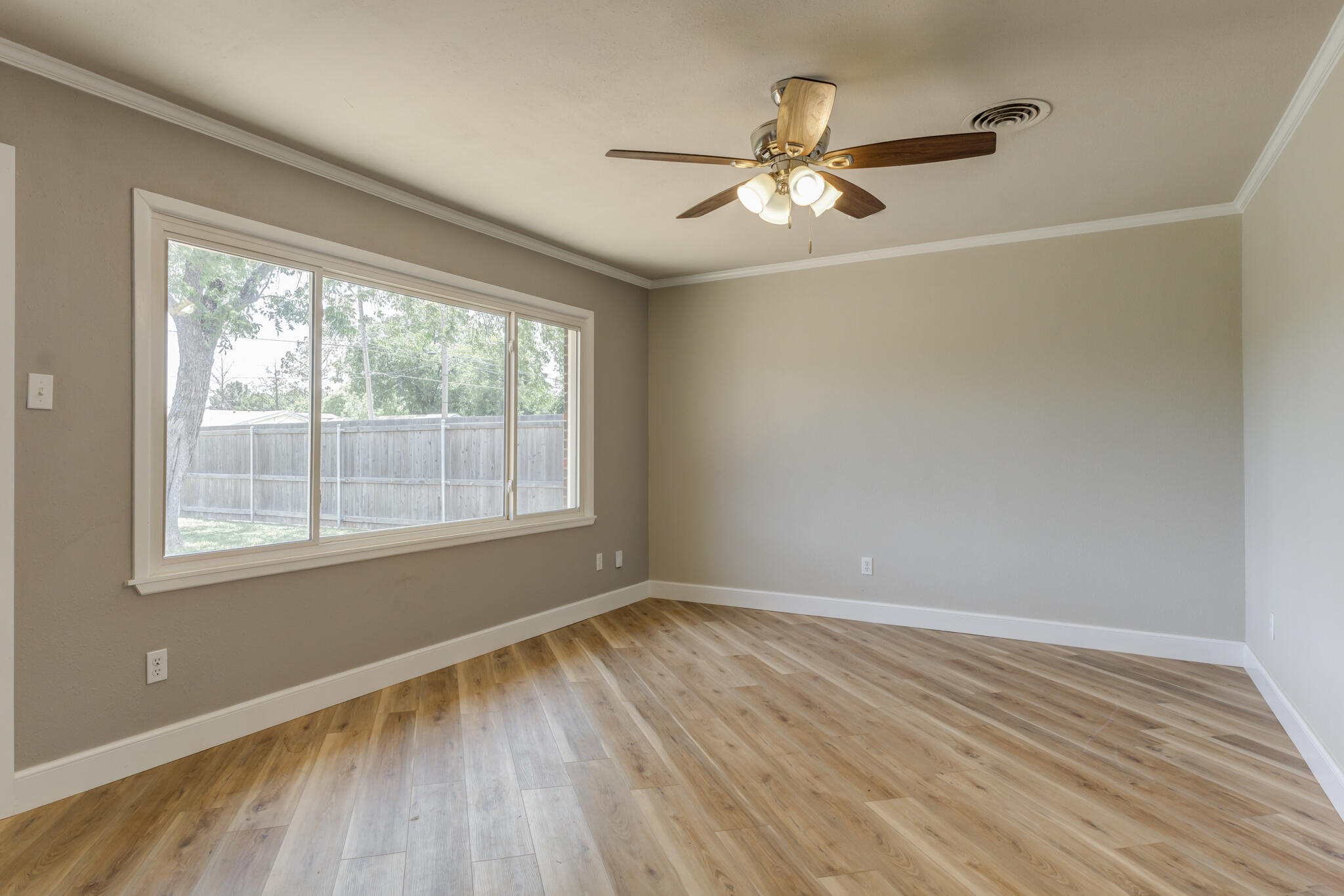 4921 10th Street Lubbock, TX 79416 - Photo 4 of 29 a view of an empty room with wooden floor and a window