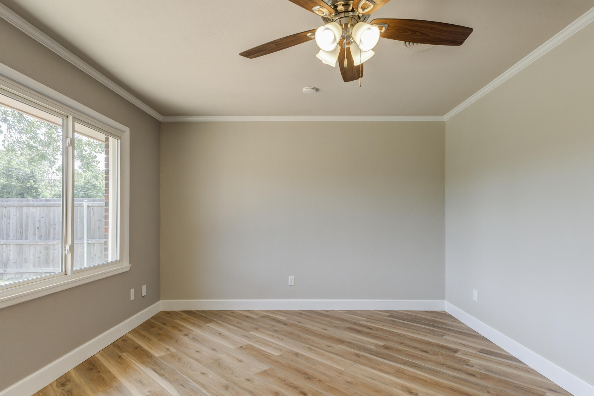 4921 10th Street Lubbock, TX 79416 - Photo 5 of 29 an empty room with wooden floor chandelier fan and windows