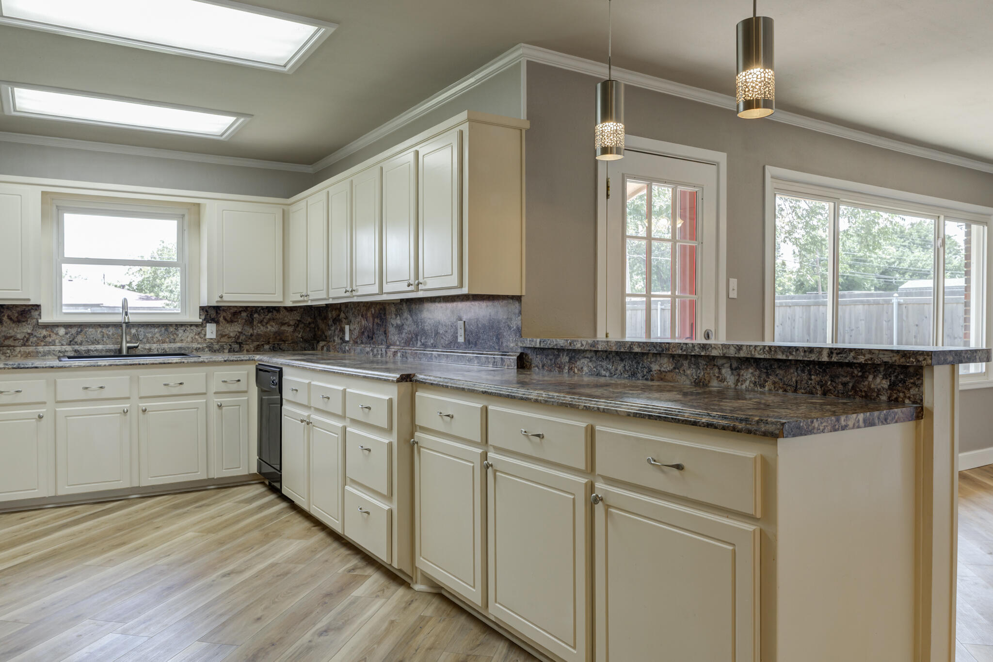 4921 10th Street Lubbock, TX 79416 - Photo 7 of 29 a kitchen with granite countertop cabinets stainless steel appliances a sink and a window