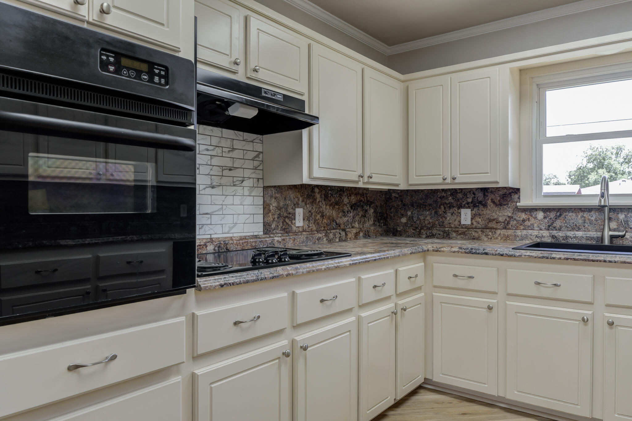 4921 10th Street Lubbock, TX 79416 - Photo 9 of 29 a kitchen with white cabinets and black appliances