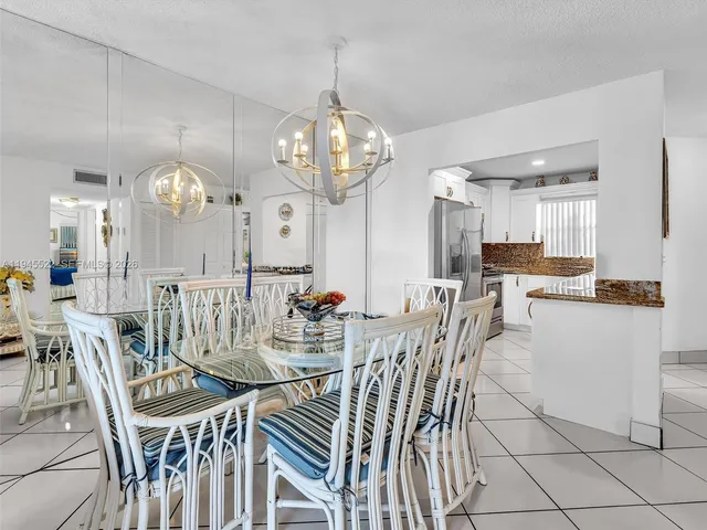 a living room with furniture a dining table and a potted plant