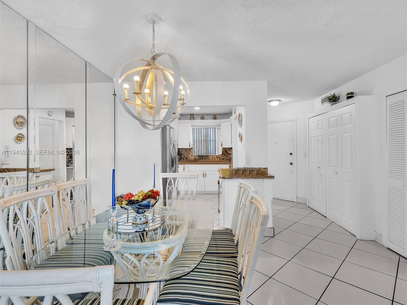 1750 West 46th Street, Unit 404 Hialeah, FL 33012 - Photo 18 of 42 a view of a dining room with furniture a chandelier and wooden floor