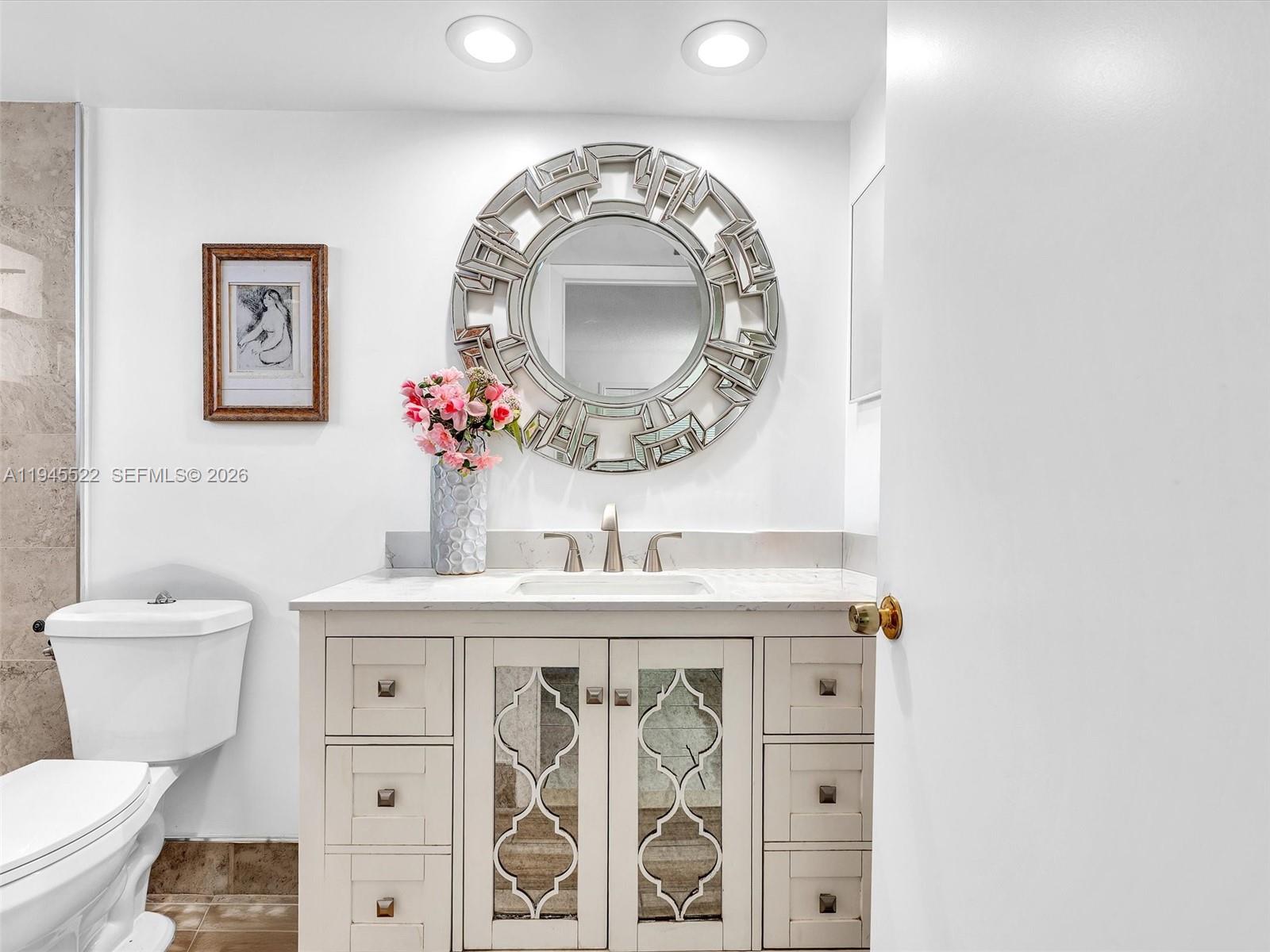 1750 West 46th Street, Unit 404 Hialeah, FL 33012 - Photo 27 of 42 a bathroom with a toilet sink vanity and mirror