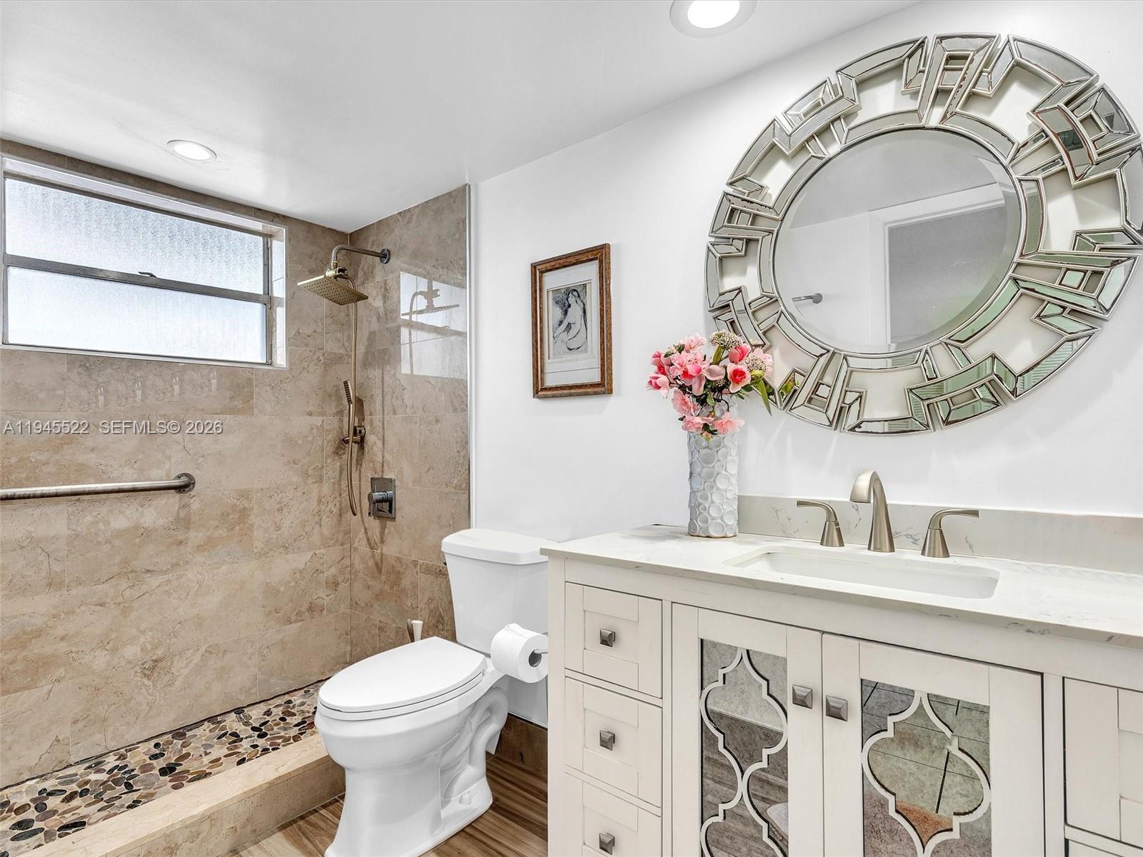 1750 West 46th Street, Unit 404 Hialeah, FL 33012 - Photo 28 of 42 a bathroom with a toilet sink mirror and vanity