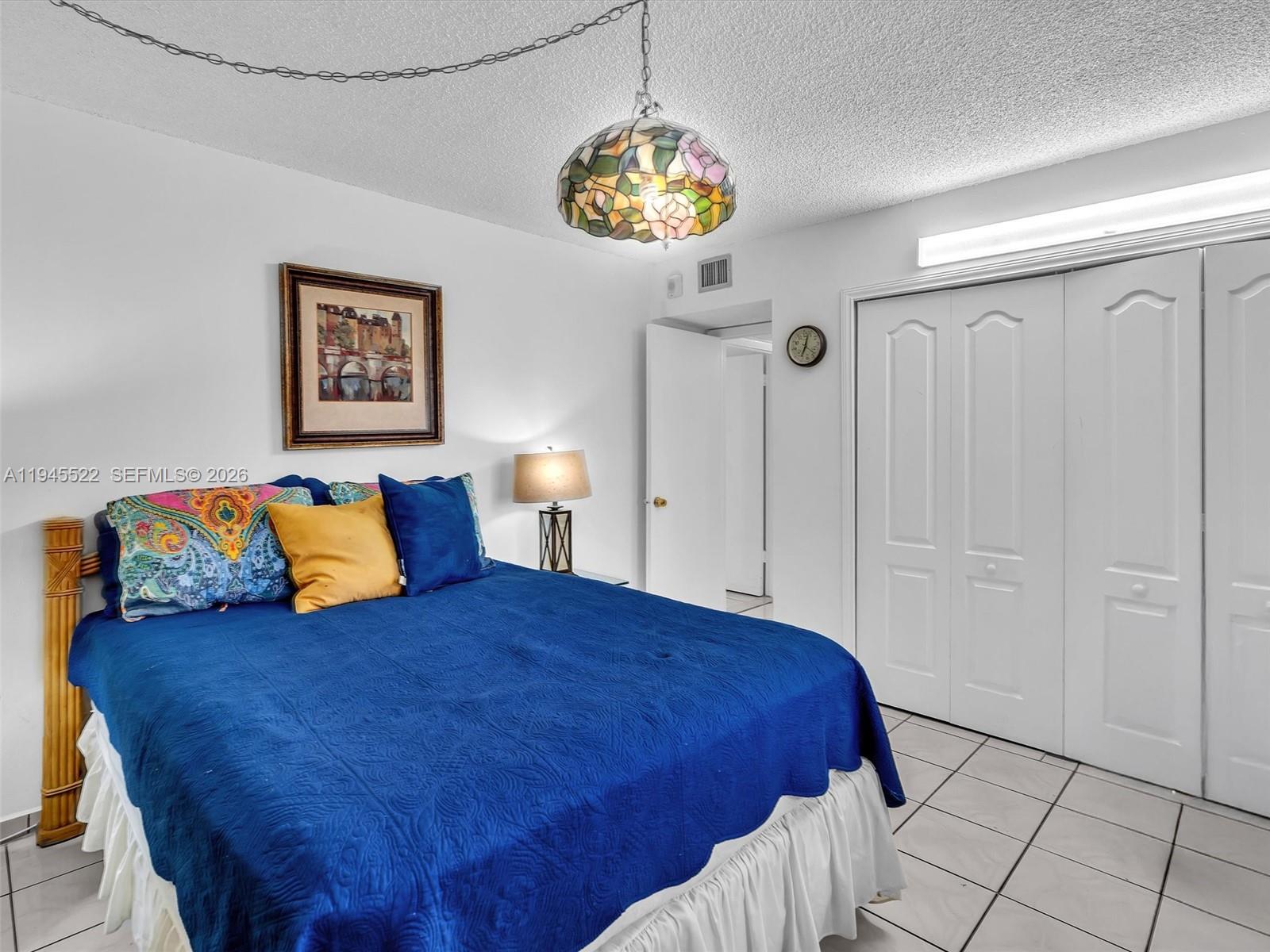 1750 West 46th Street, Unit 404 Hialeah, FL 33012 - Photo 30 of 42 a bedroom with a bed and a chandelier