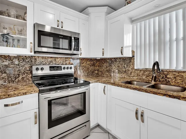 a kitchen with cabinets stainless steel appliances a sink and a counter space