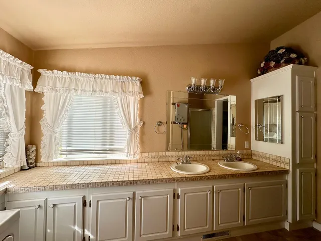 a bathroom with a granite countertop sink and a large mirror