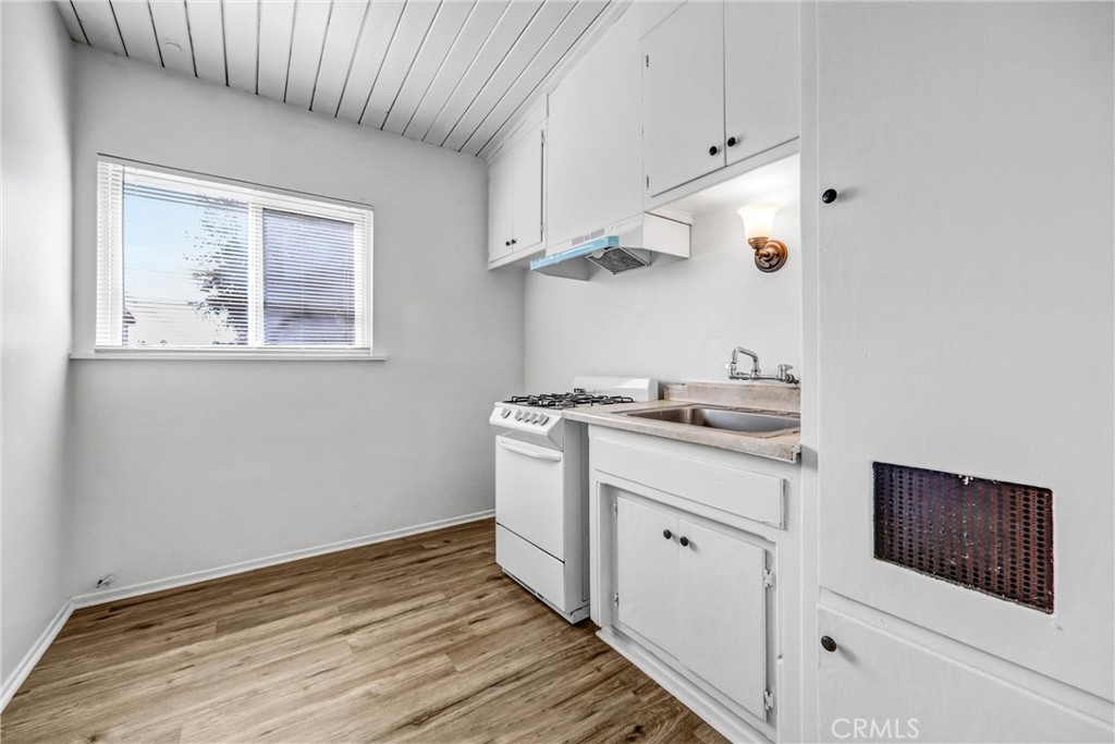 3622 East Colorado Boulevard, Unit 5 Pasadena, CA 91107 - Photo 4 of 12 a kitchen with stainless steel appliances white cabinets and wooden floor