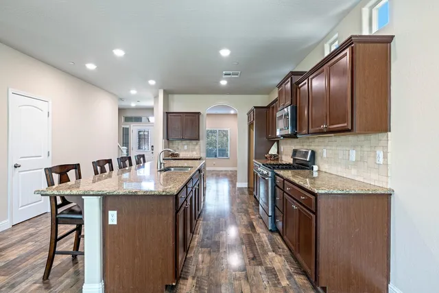 a kitchen with kitchen island a sink and wooden floor
